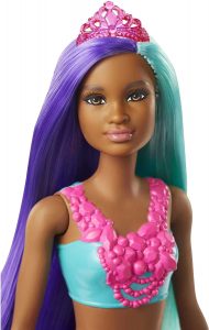 Face of a black mermaid doll with purple and blue hair.