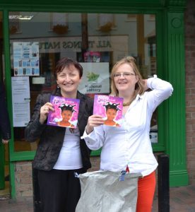 twowomen with post bag full of books outside a rural irish post office