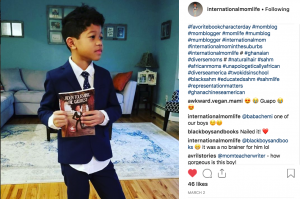 A boy dressed as the book character Jaden Toussaint holds a copy of the Jaden Toussaint book by author Marti Dumas.