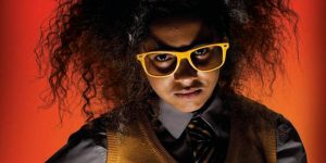 Scowling schoolgirl in yellow glasses with Albert Einstein hair-do