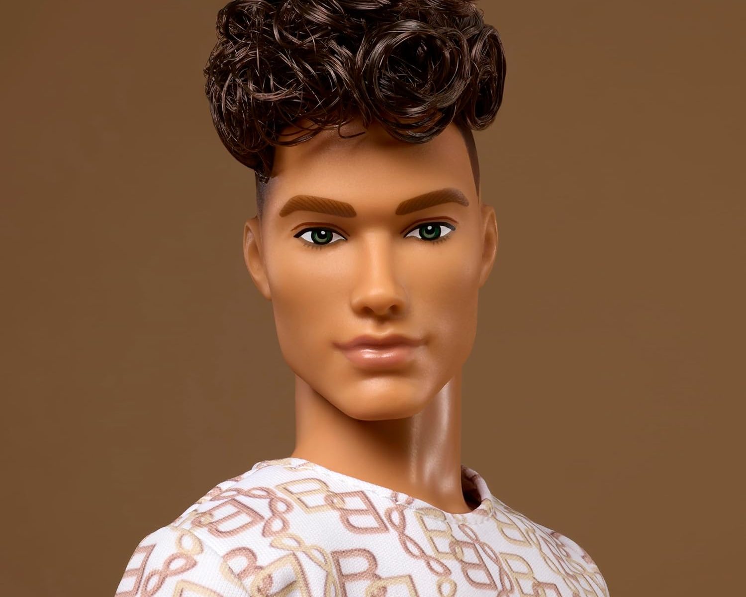 male Barbie doll head and shoulders with a pile of curls on top of his head and shaved sides