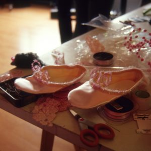 a table with ballet shoes and seamstress's equipment