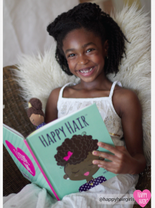 Smiling young black girl reading a book